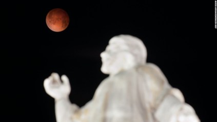 The moon is pictured over the El Salvador del Mundo Monument in San Salvador, El Salvador on April 15, 2014 as a lunar eclipse begins across the Americas. The entire event was to be visible from North and South America, but sky watchers in northern and and eastern Europe, eastern Africa, the Middle East and Central Asia were out of luck, according to US space agency NASA. AFP PHOTO/ Jose CABEZAS (Photo credit should read JOSE CABEZAS/AFP/Getty Images)
